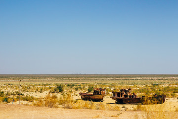 Old rustic boats and ships in a desert around Moynaq, Muynak or Moynoq - Aral sea or Aral lake - Uzbekistan, Central Asia.