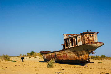 Old rustic boats and ships in a desert around Moynaq, Muynak or Moynoq - Aral sea or Aral lake - Uzbekistan, Central Asia.