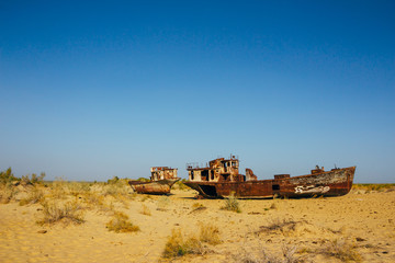 Fototapeta na wymiar Old rustic boats and ships in a desert around Moynaq, Muynak or Moynoq - Aral sea or Aral lake - Uzbekistan, Central Asia.