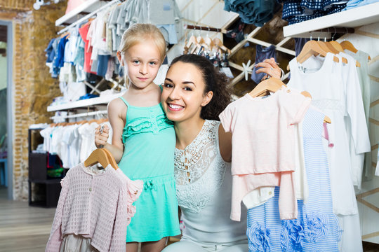 portrait of  woman and girl shopping kids apparel in clothes sto
