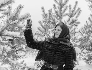 Fototapeta na wymiar black and white beautiful girl in the snowy forest .
