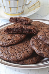 Fudge brownie cookies on crockery plate and cup
