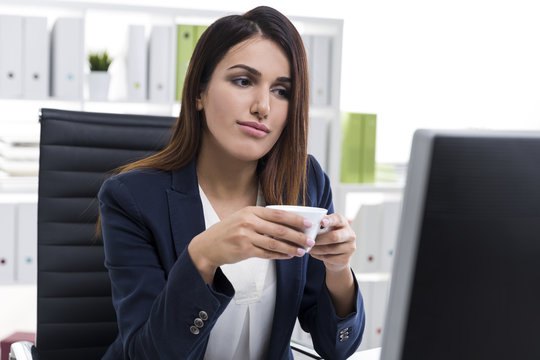 Nostalgic businesswoman with a cup of coffee in an office