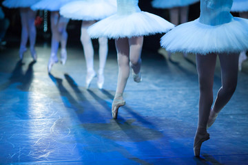 Ballerinas in the movement. Feet of ballerinas close up.