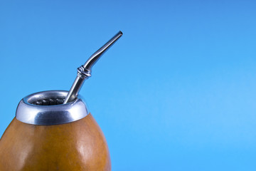 yerba mate with bombilla on blue background