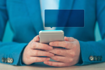 Businesswoman using smartphone, speech ballon as copy space