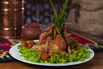 Chicken Tabaka with potatoes and lettuce on a white plate