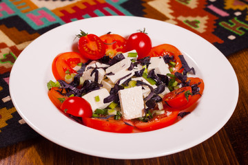 Fresh tomatoes with cheese and cauliflower on a white plate
