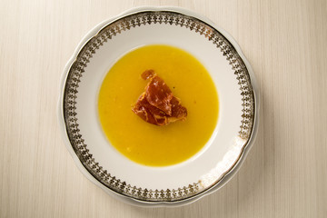 Pumpkin Soup with proschiuto on table