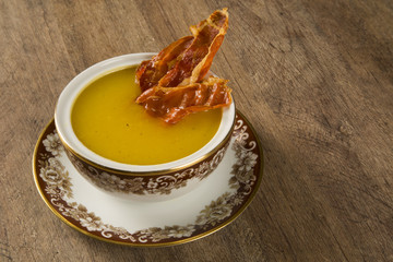 Pumpkin Soup with proschiuto on table
