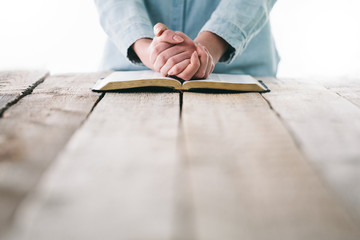 Bible in hands of a woman. She is readind and praying over it