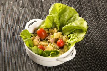 Salad with German sausage, cheese topped with tomato