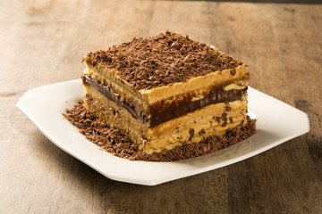close up of a chocolate cream cake on white plate