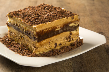 close up of a chocolate cream cake on white plate