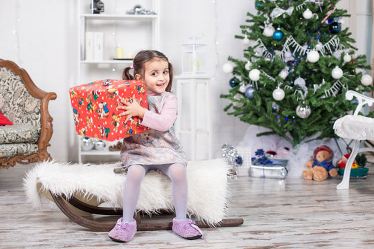 Bambina sorridente che tiene un pacco regalo