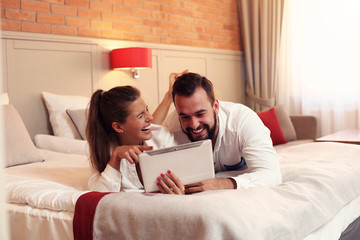 Happy couple resting in hotel room