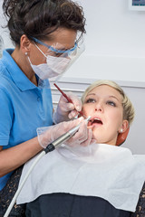 Zahnarzthelferin bei Zahnreinigung an Patientin