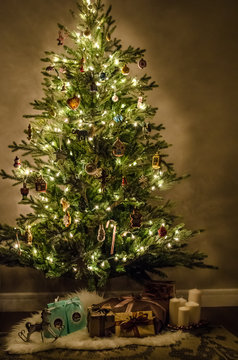 Christmas tree with beautiful lights, decoration, toys and gifts indoors