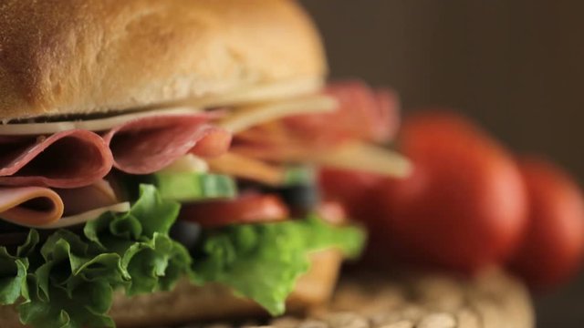 Sub sandwich with fresh vegetables, lunch meat and cheese on hoagie roll