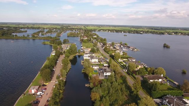 Road and houses in Holland surrounded by water, aerial.
