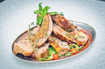 meat on the bone grilled over charcoal served with herbs and vegetables