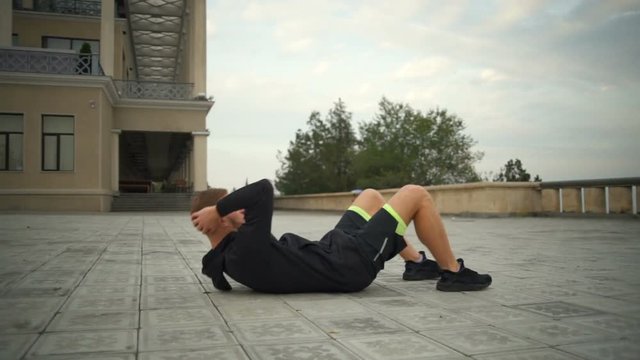 Young handsome man with healthy lifestyle doing sit ups slow motion