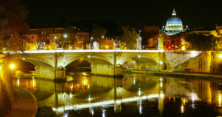 Fototapeta na wymiar The Bridges over River Tiber and St Peters Basilica in Rome by night