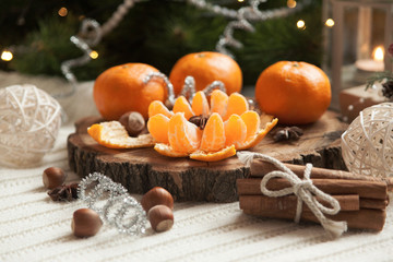 tangerines and cinnamon on the table near the Christmas tree