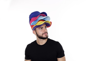 Attraktiver junger Mann mit Bart trägt verschiedene Basecaps auf dem Kopf