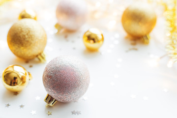 Christmas and New Year background with golden decorative balls for Christmas tree with light bulbs and confetti. Place for text.