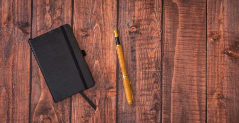 Office supplies on wooden table. Top view. Notebook, pen, tablet