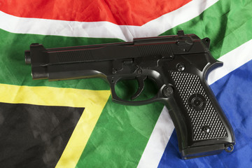 Violent crime concept with handgun and South African flag
