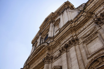 Bottom view of a historical building in Rome with clear blue sky in the background.