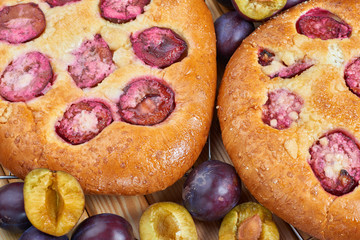 Home made plum buns on a wooden table