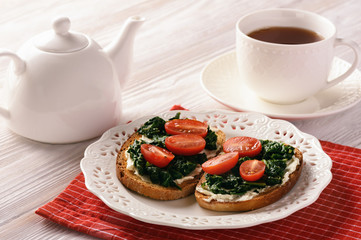 Toasts with spinach, cream cheese and tomatoes.