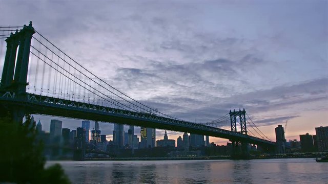 Manhatten bridge with the distinctive New York skyline in background at sunset, New York , United States