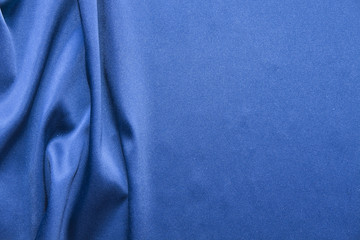 Fototapeta premium Blue silk background. Abstract wavy texture