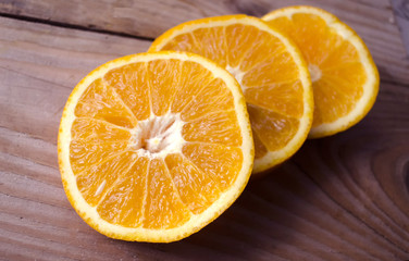 Fresh oranges sliced on wooden table. Still life of ripe fruit. Sliced juicy citrus fruits. Orange background. Close-up of orange fruit