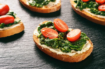 Toasts with spinach, cream cheese and tomatoes.