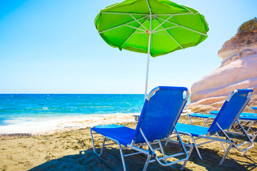 Summer beach with sun beds and umbrella.