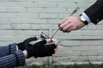 Female hands in gloves, holding a mug. In the man's hand luxury watches. Hand male holding a ladle.
