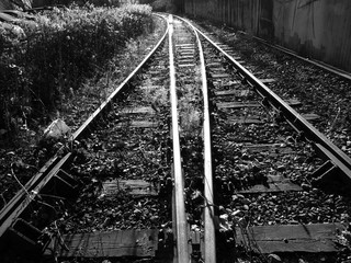 Bahngleis mit Weiche im Schienenverlauf im Gegenlicht an einer stillgelegten Bahnlinie am...