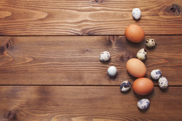 Chicken and quail eggs on wooden background