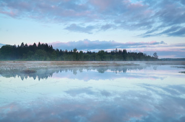 sunrise sky reflections in wild forest lake