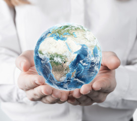 Woman in a white blouse holding a small planet