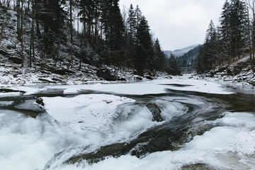 Fototapeta na wymiar Winter river in mountains.