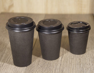 three paper Cup of black coffee on wooden background