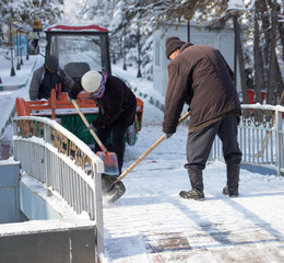 Fototapeta premium Worker cleans snow shovel in the nature