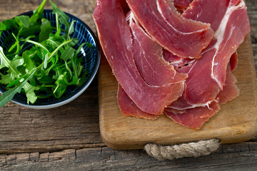 jamon and rucola on wooden surface