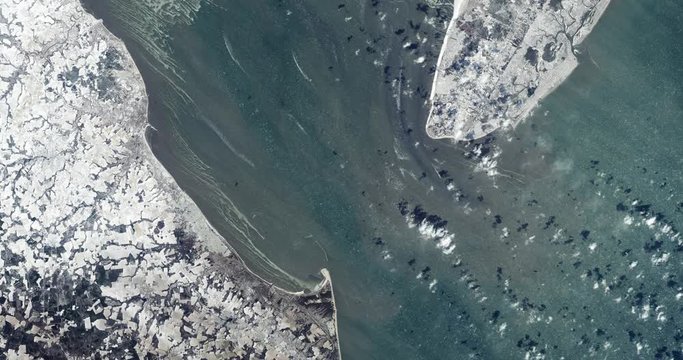 High-altitude overflight aerial of a frozen mouth of the Delaware Bay. Clip loops and is reversible. Elements of this image furnished by USGS/NASA Landsat 

